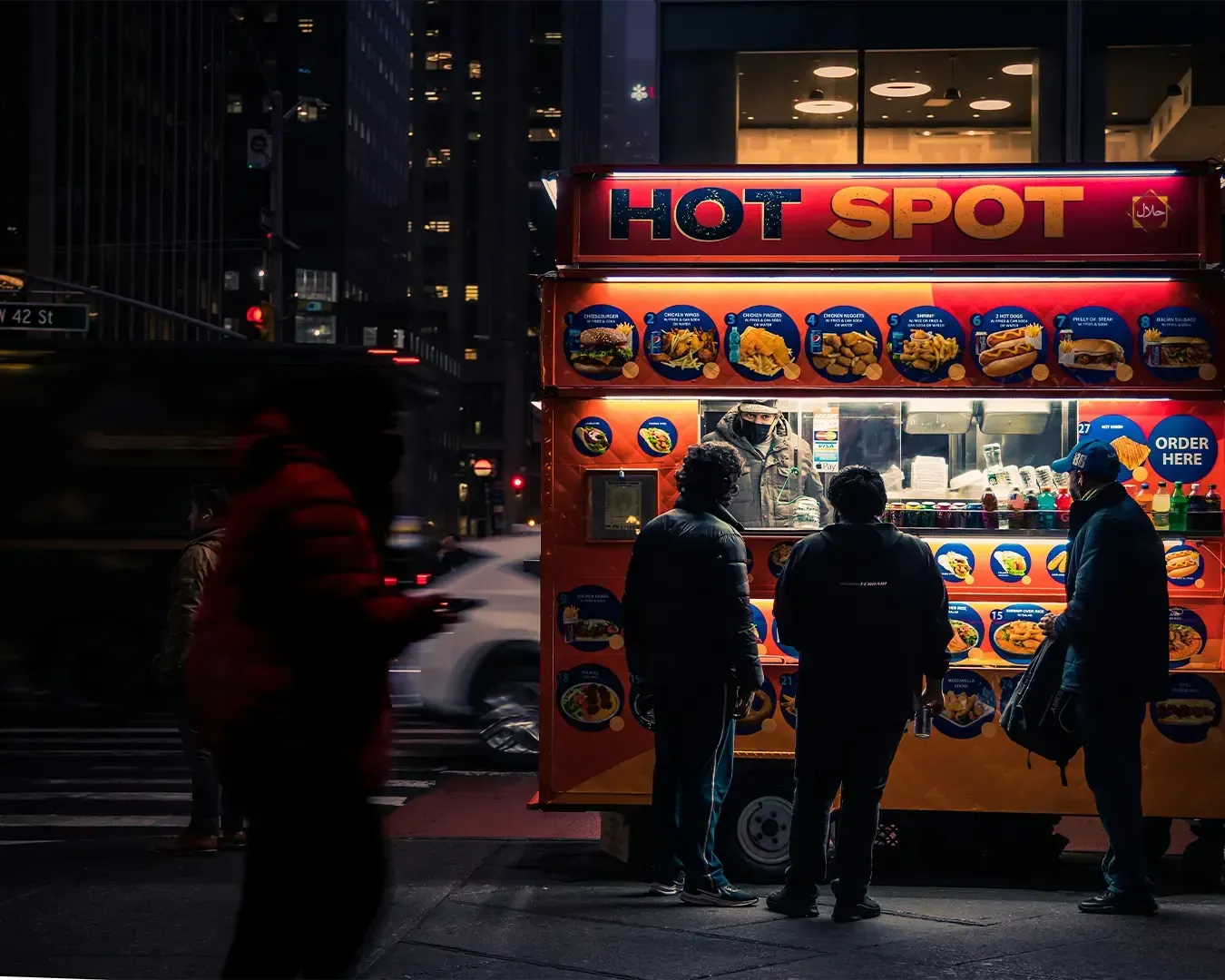 A lively night scene where a small crowd gathers around a brightly lit food truck, ordering and coll