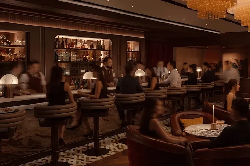 A warmly lit, upscale hidden bar interior featuring massive, tiered crystal chandeliers. Bartenders mixes cocktails behind a marble counter while patrons converse in plush red armchairs in a refined, cozy setting and on the bar counter socializing and drinking in luxurious drinks.