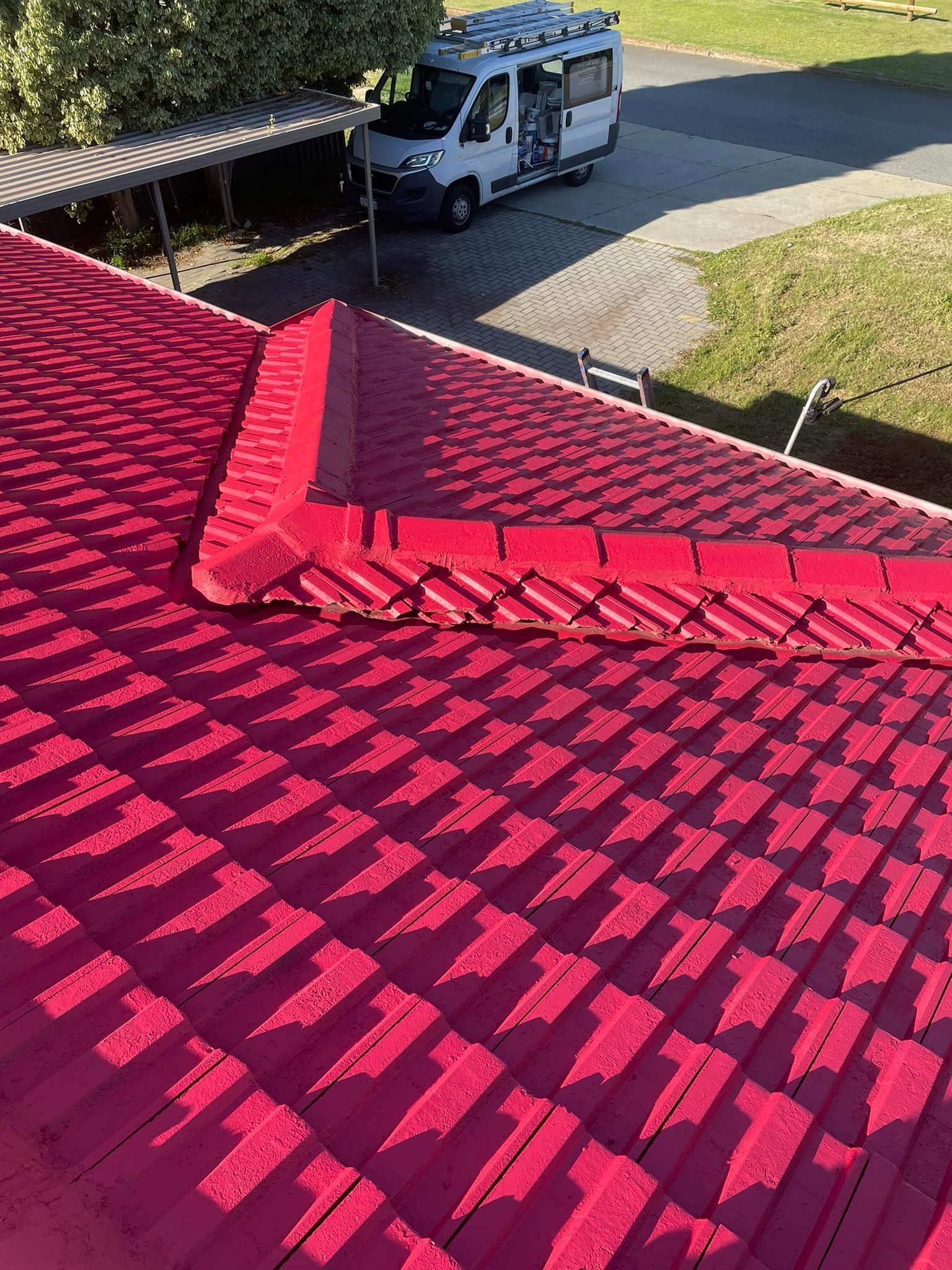 Red metal roof with a camper van parked nearby.
