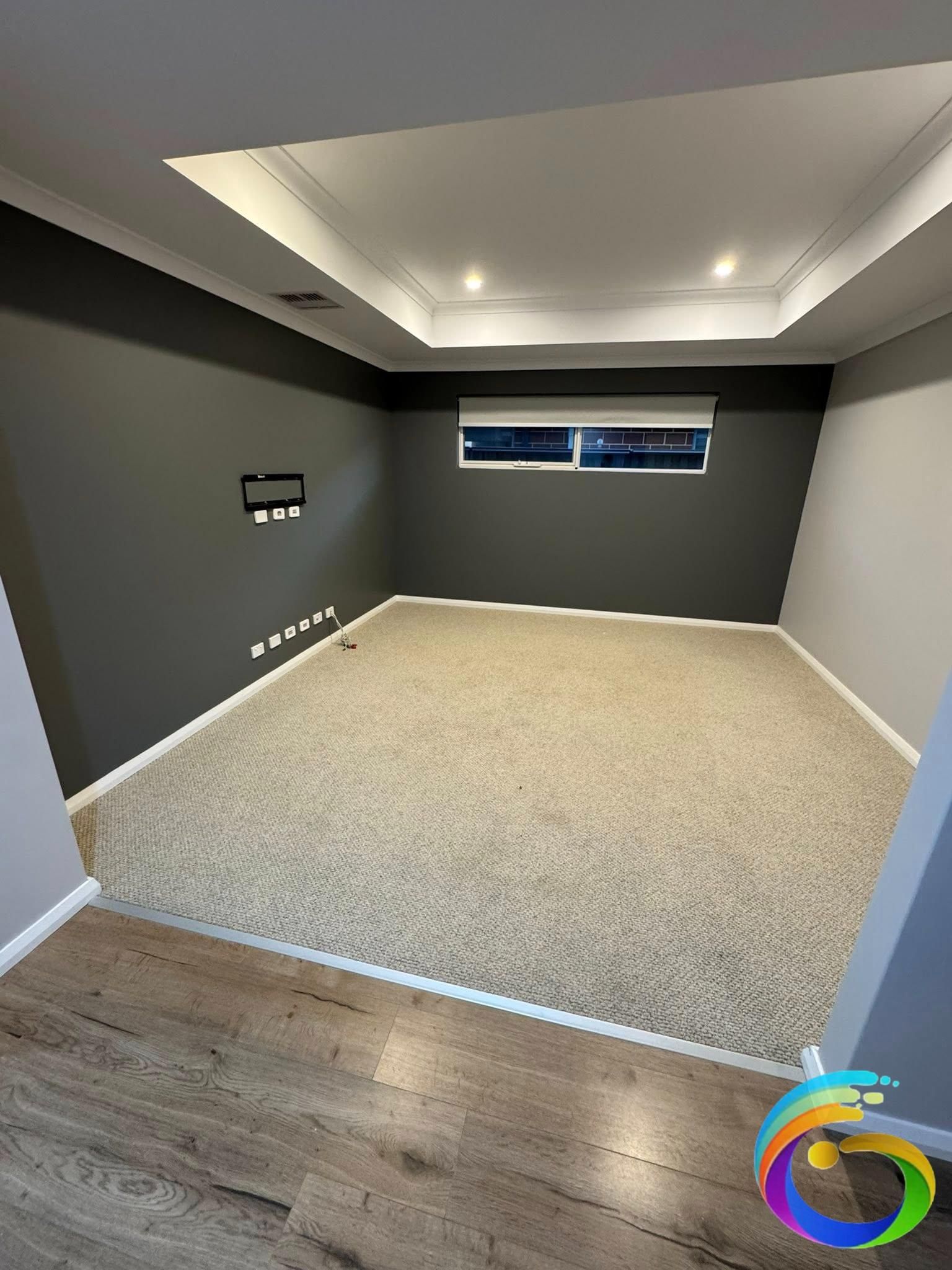 Empty room with dark gray walls, beige carpet, and a white ceiling with recessed lights.