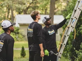 A group of men are standing next to a ladder.