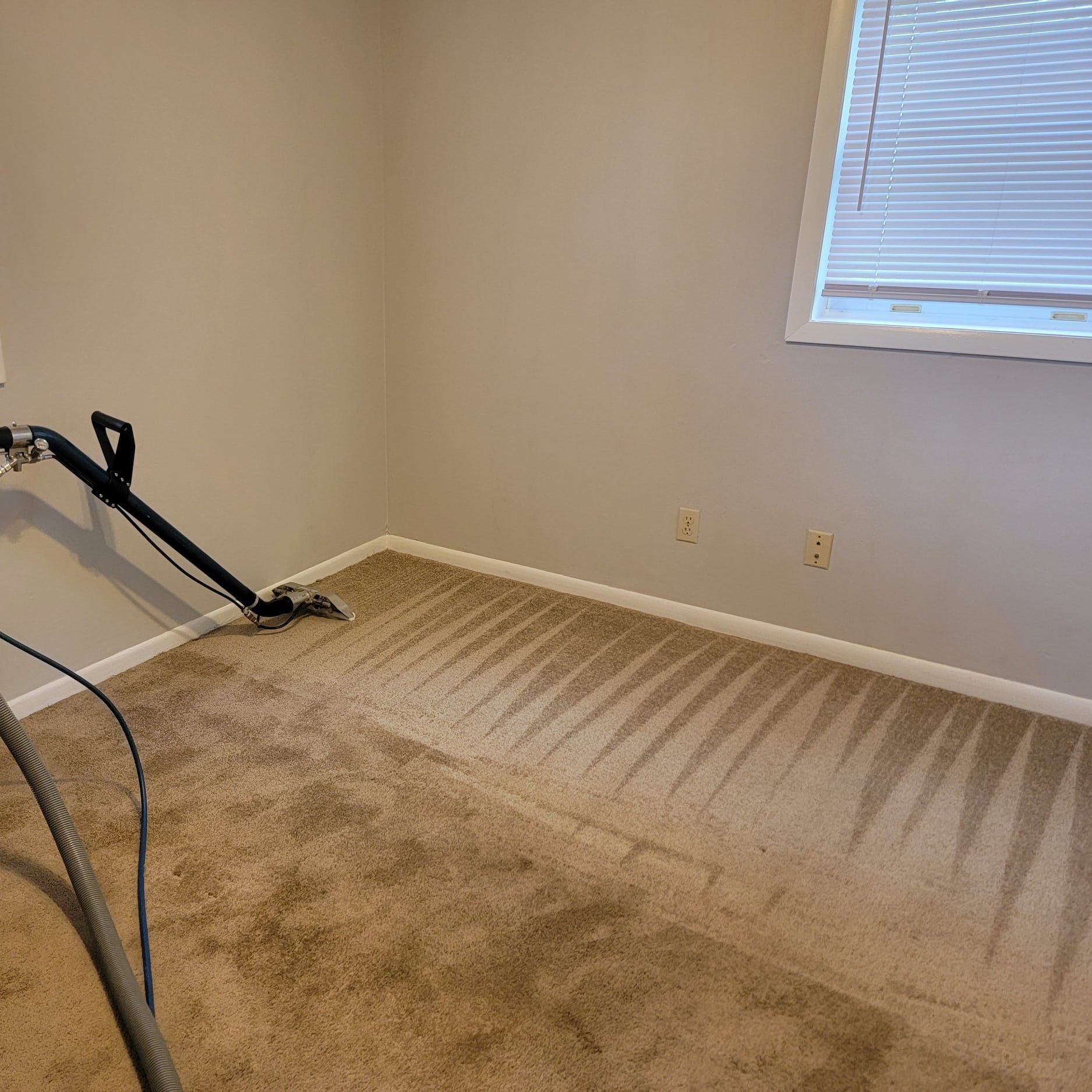 A room with a vacuum cleaner on the floor and a window.