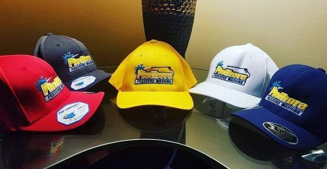 A bunch of hats are sitting on a table and one of them has the word falcons on it