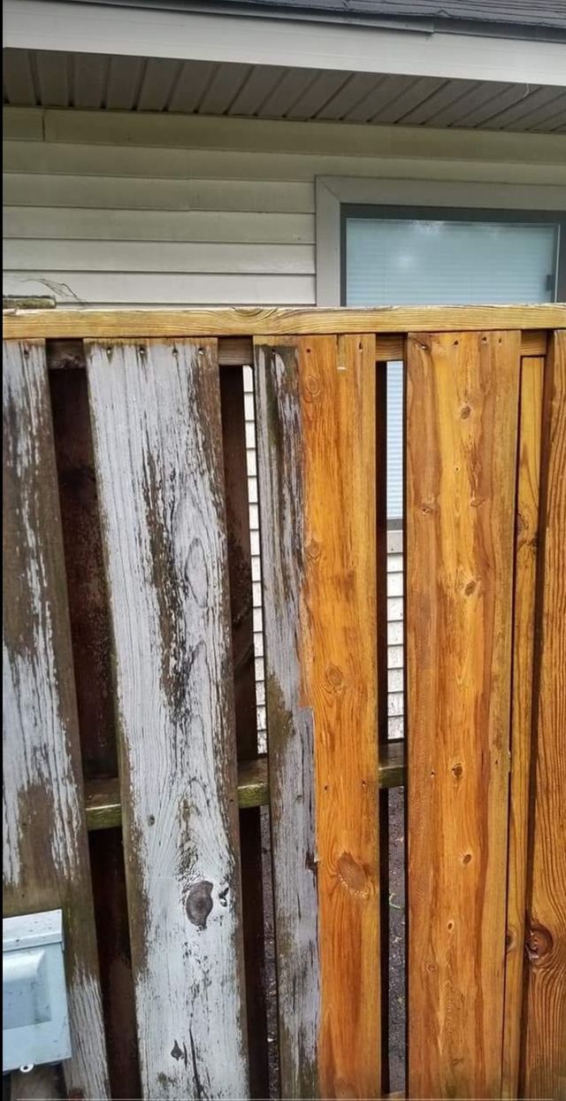 A wooden fence is sitting in front of a house.