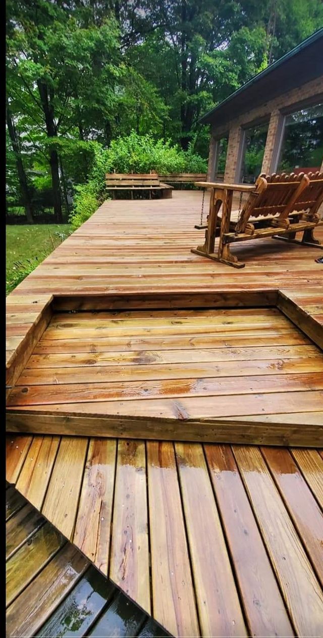A wooden deck with chairs and a table on it.