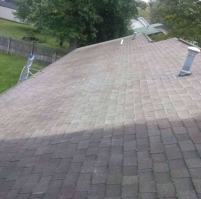 A roof with a skylight and a ladder on it.