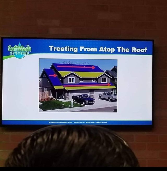 A man is watching a presentation about treating from atop the roof
