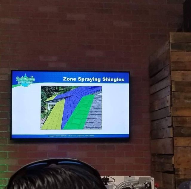 A man sitting in front of a screen that says zone spraying shingles