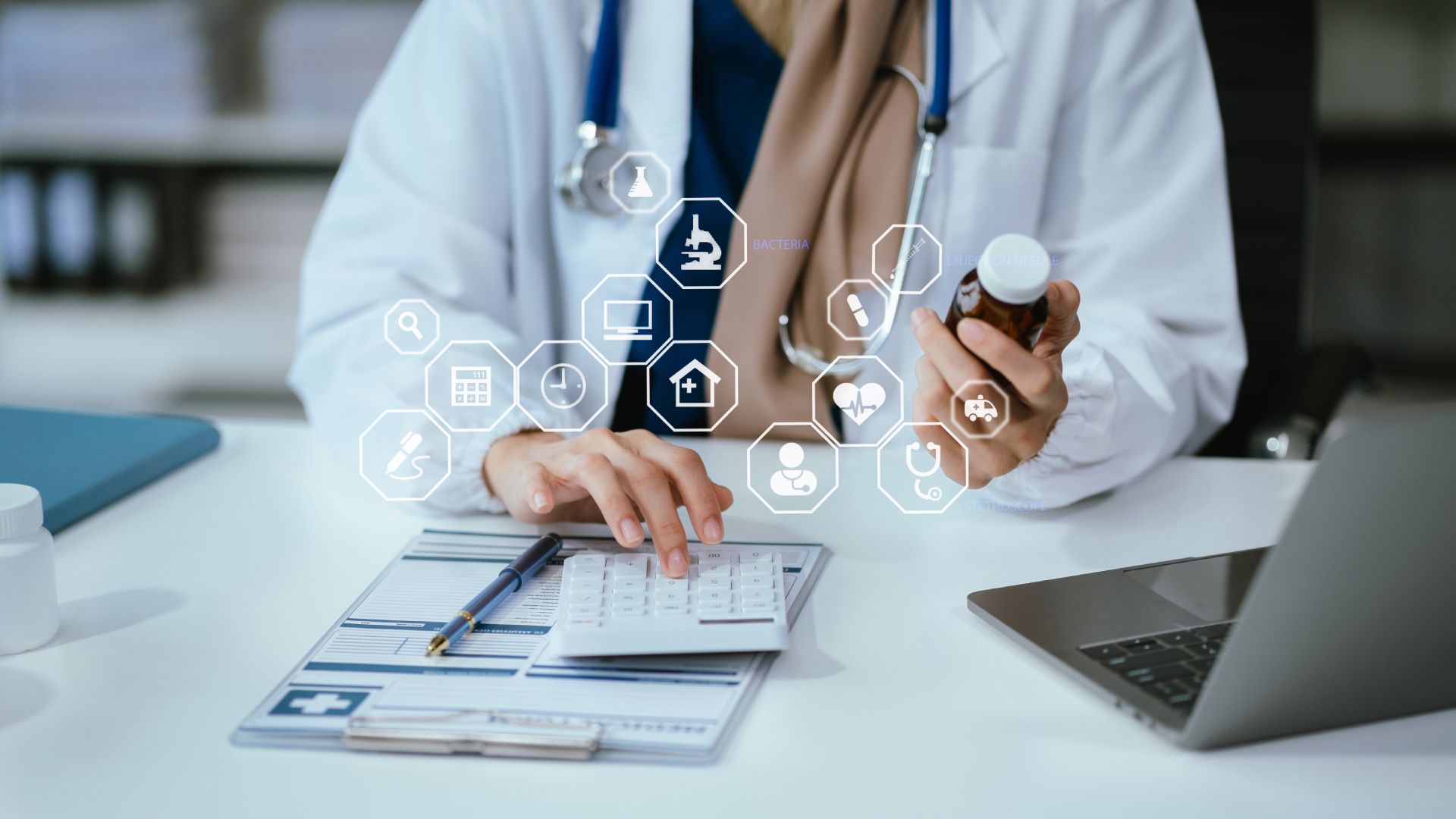 A doctor is sitting at a desk holding a bottle of pills.