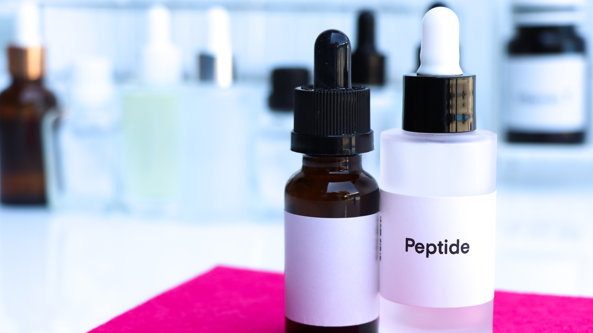 Two bottles of peptide serum are sitting on a table.