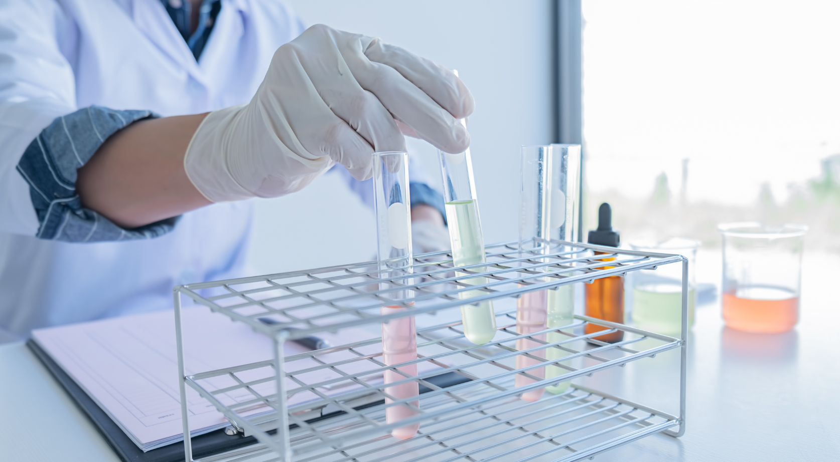 A scientist is pouring liquid into a test tube in a laboratory.