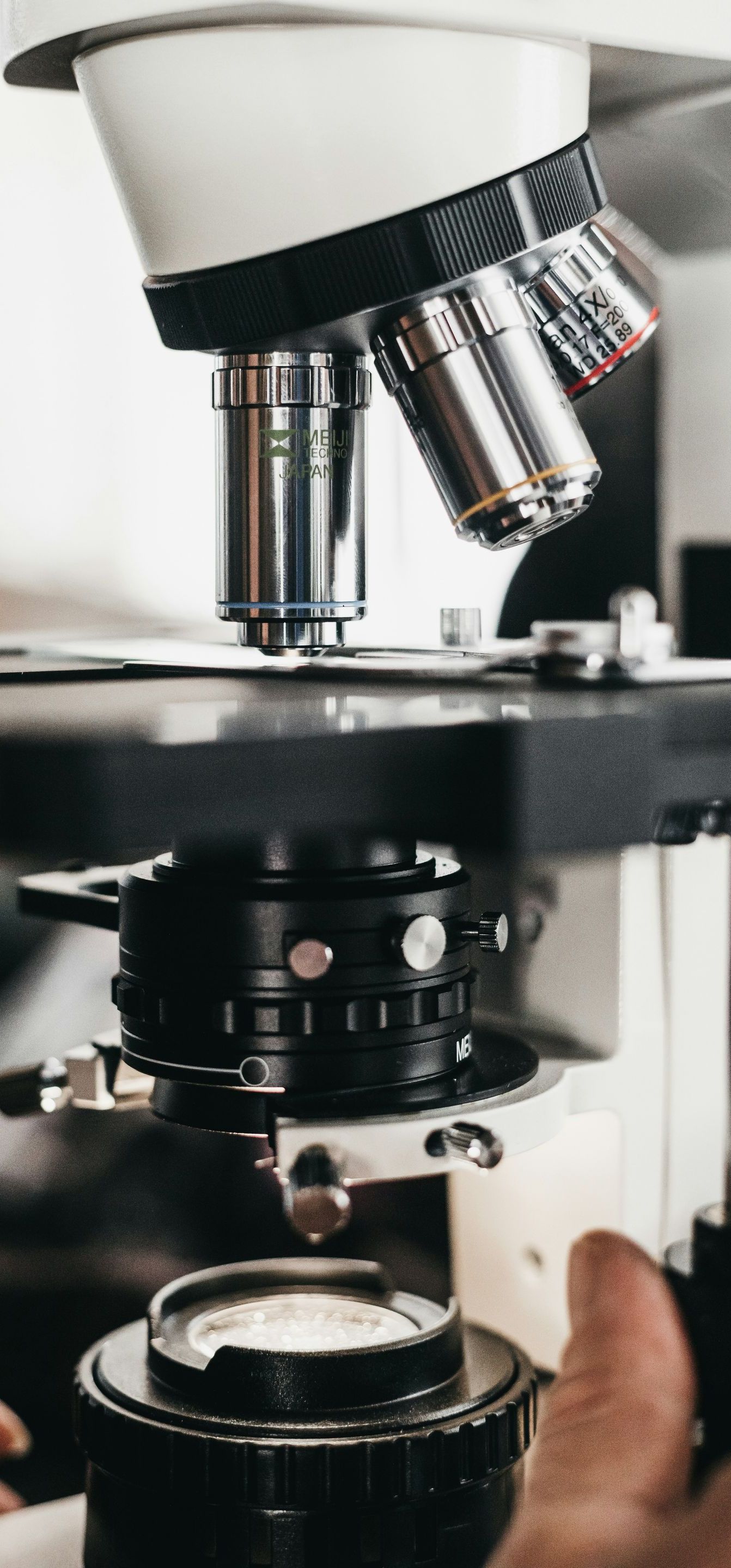 A person is holding a microscope in their hand.