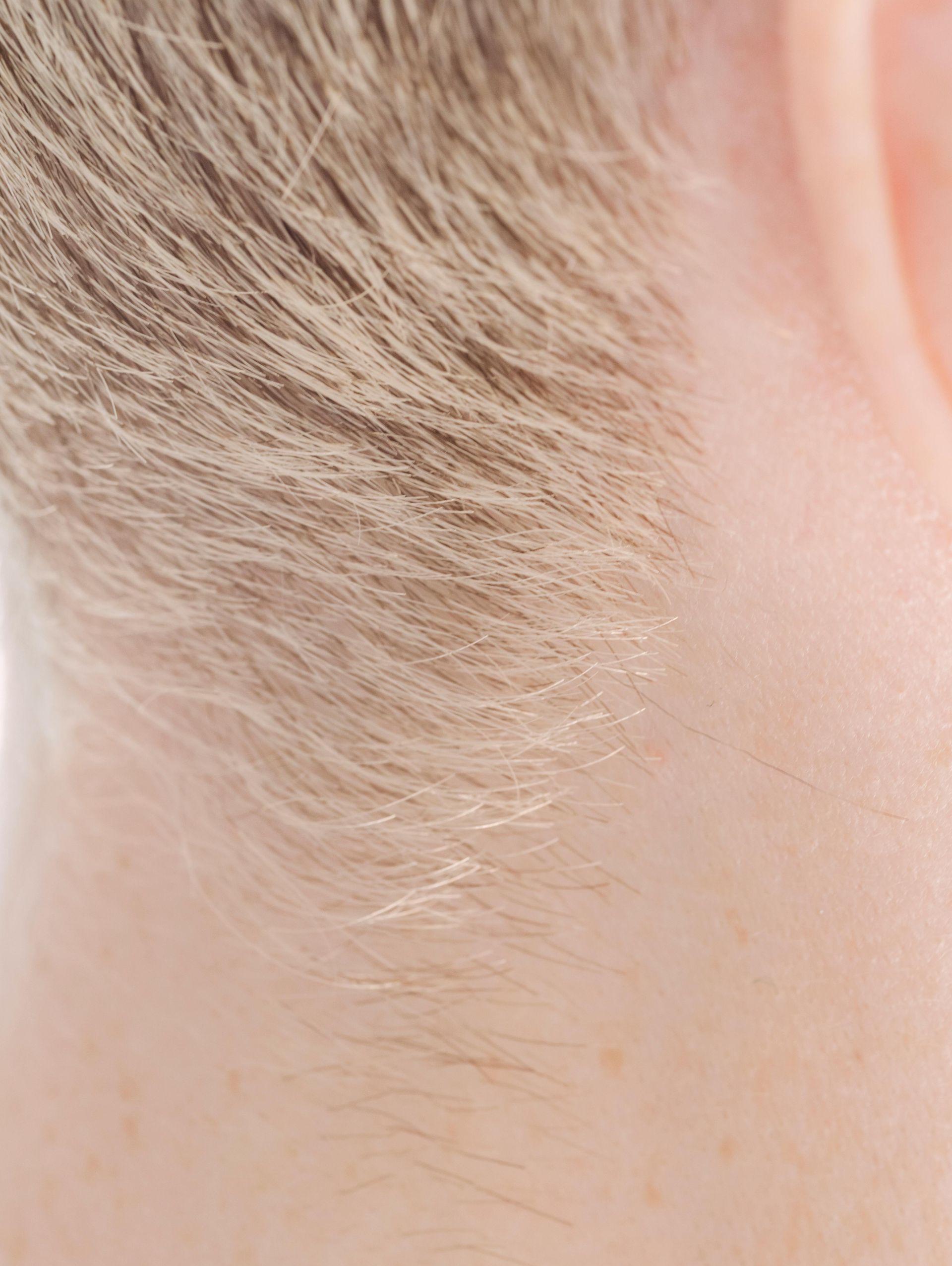 A close up of a person 's neck and ear.