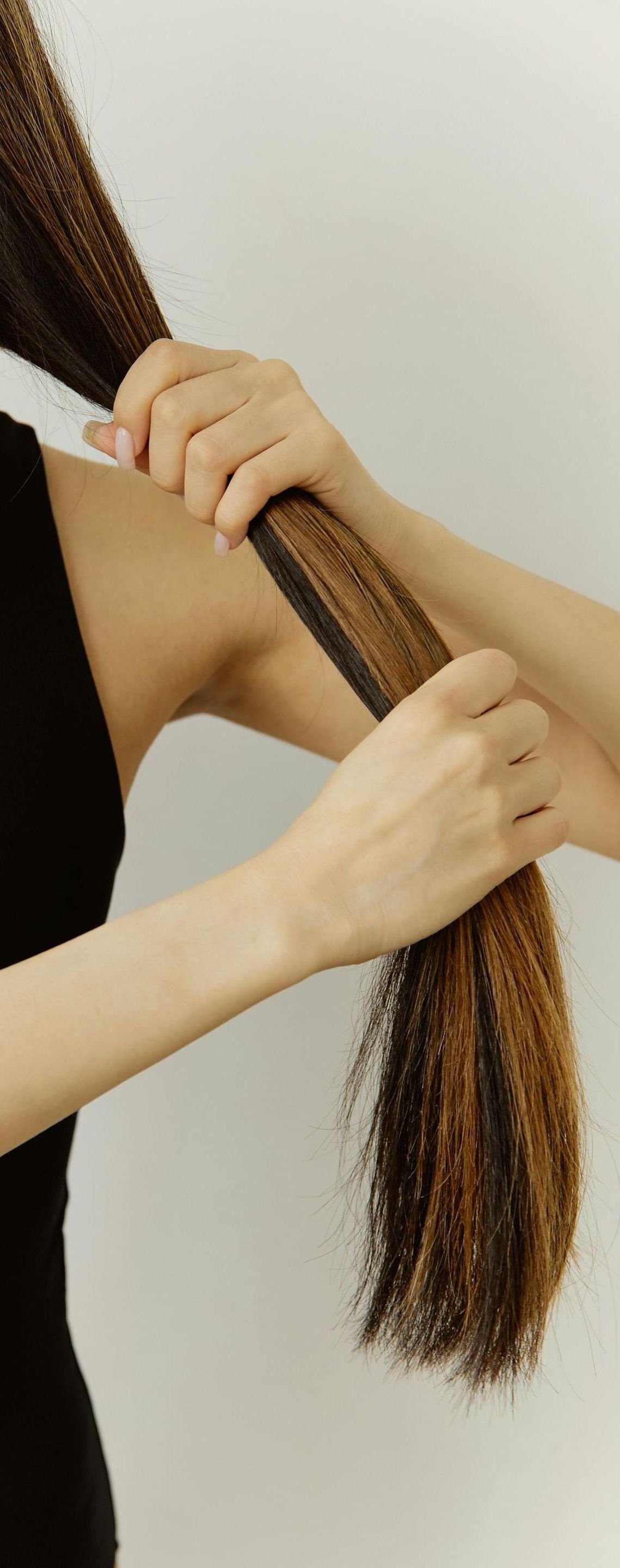 A woman is brushing her hair with a comb.