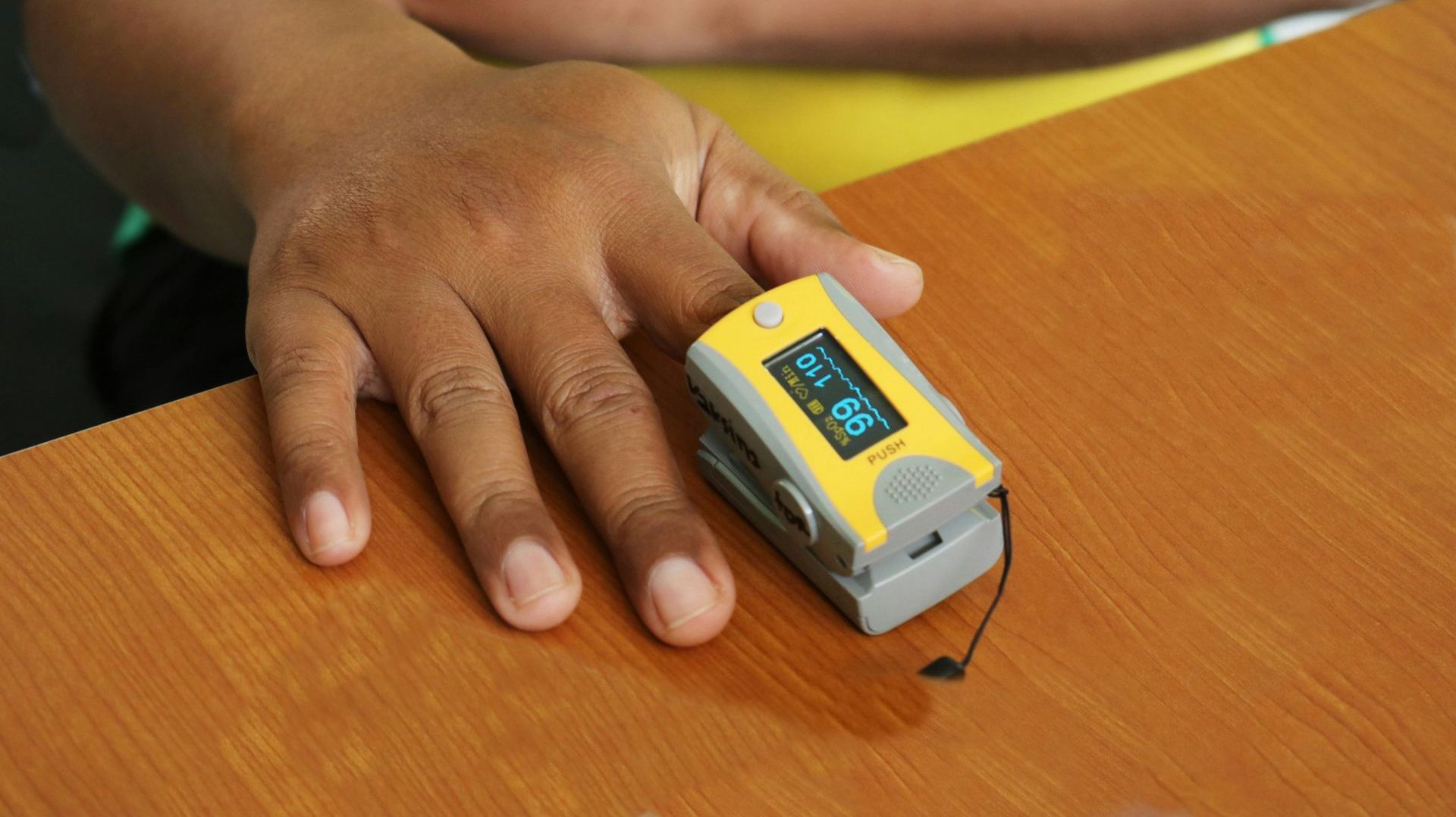 A person is using a pulse oximeter on their finger.