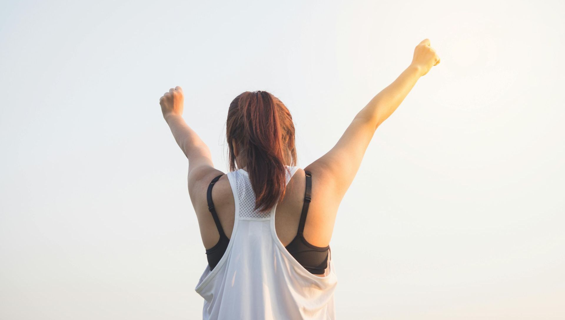 A woman is standing with her arms in the air.