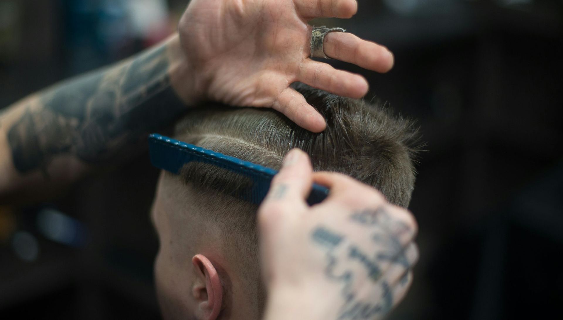 A man is getting his hair cut by a barber.