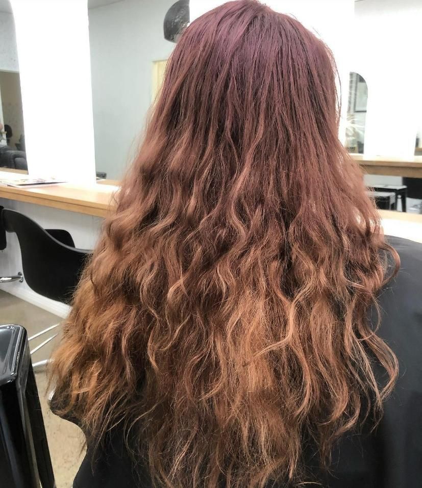 A Woman with Long Red Hair Is Sitting in A Chair in A Salon — Eden Hair in Pacific Paradise, QLD
