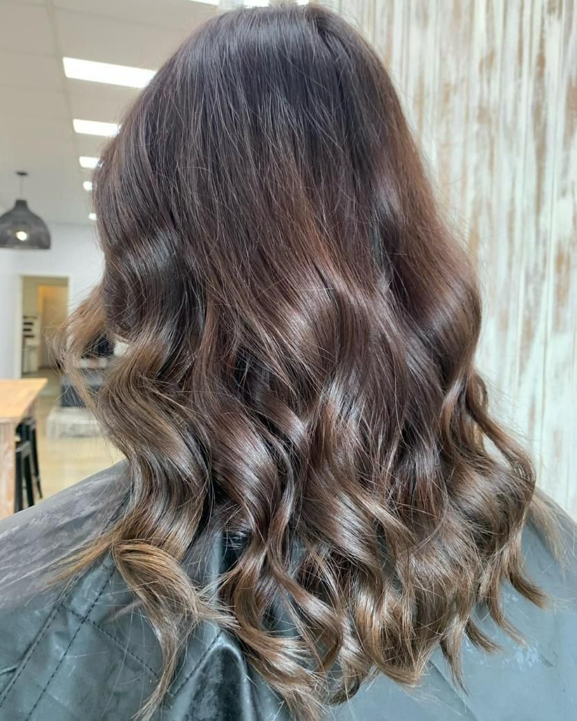 A Woman Is Sitting in A Chair with Her Hair in A Salon — Eden Hair in Pacific Paradise, QLD
