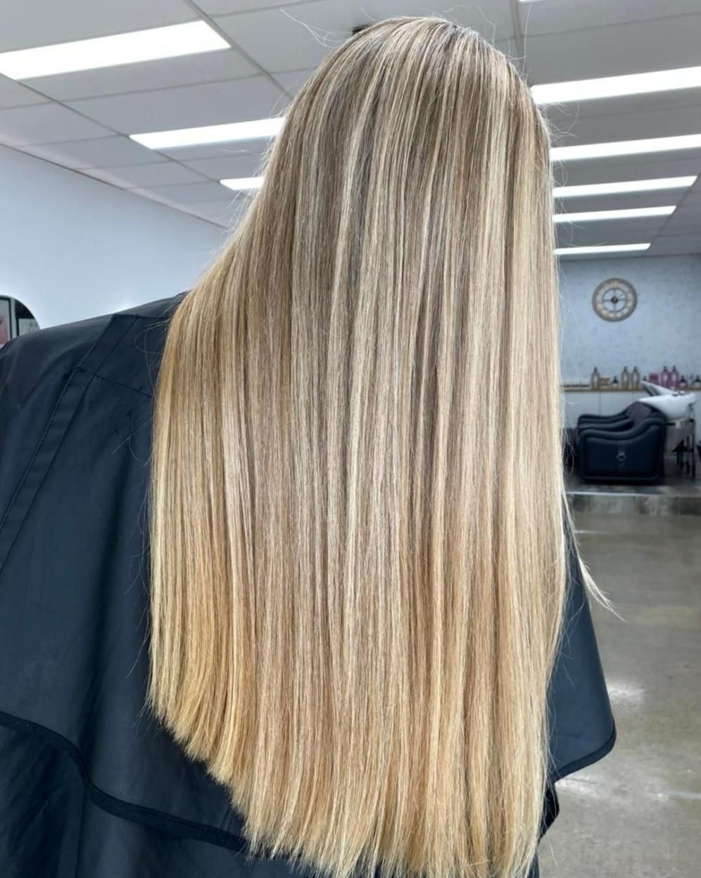 A Woman with Long Blonde Hair Is Standing in A Salon — Eden Hair in Pacific Paradise, QLD
