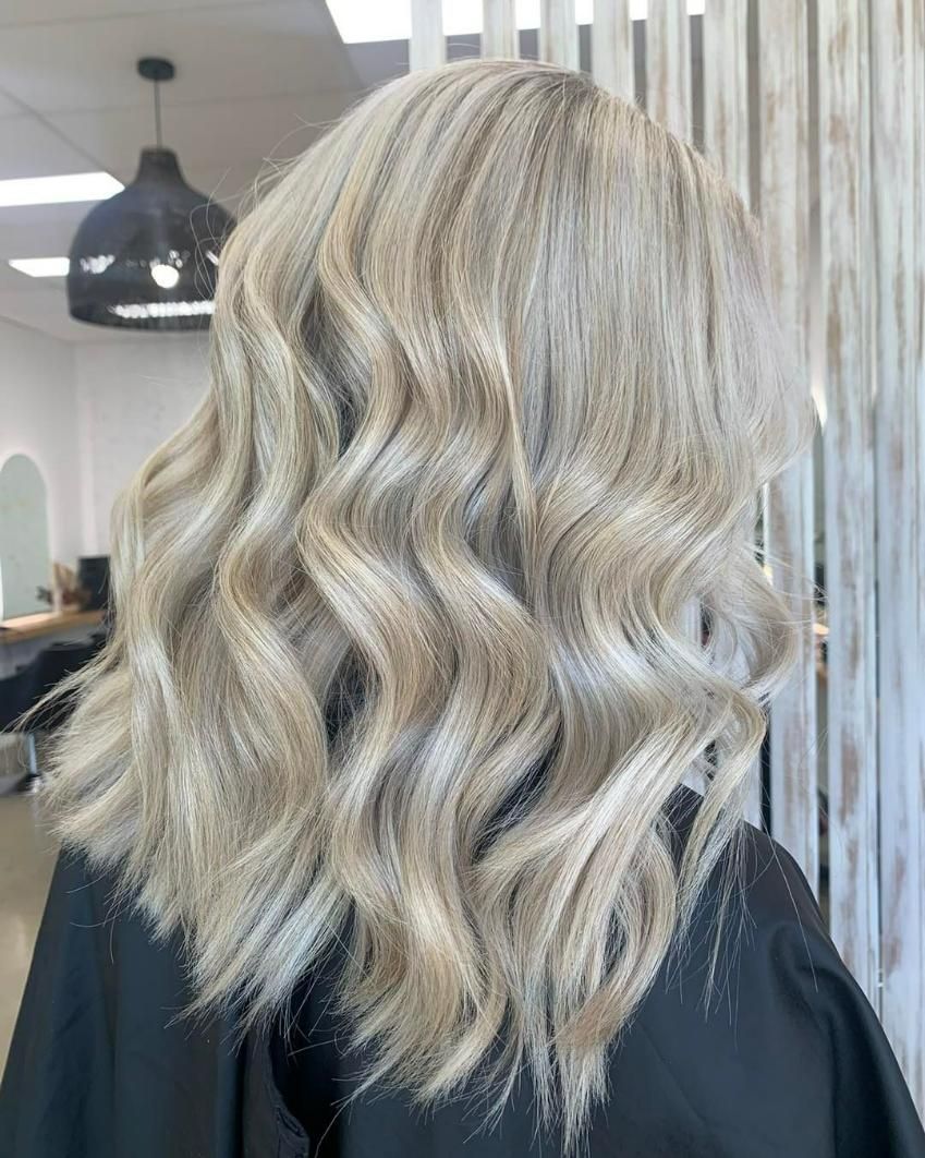 A Woman with Blonde Hair Is Sitting in A Chair in A Salon — Eden Hair in Pacific Paradise, QLD