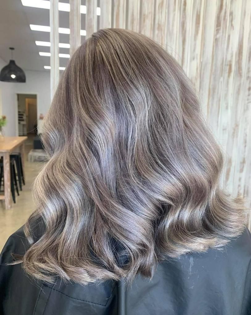 A Woman with Long Wavy Hair Is Sitting — Eden Hair in Pacific Paradise, QLD