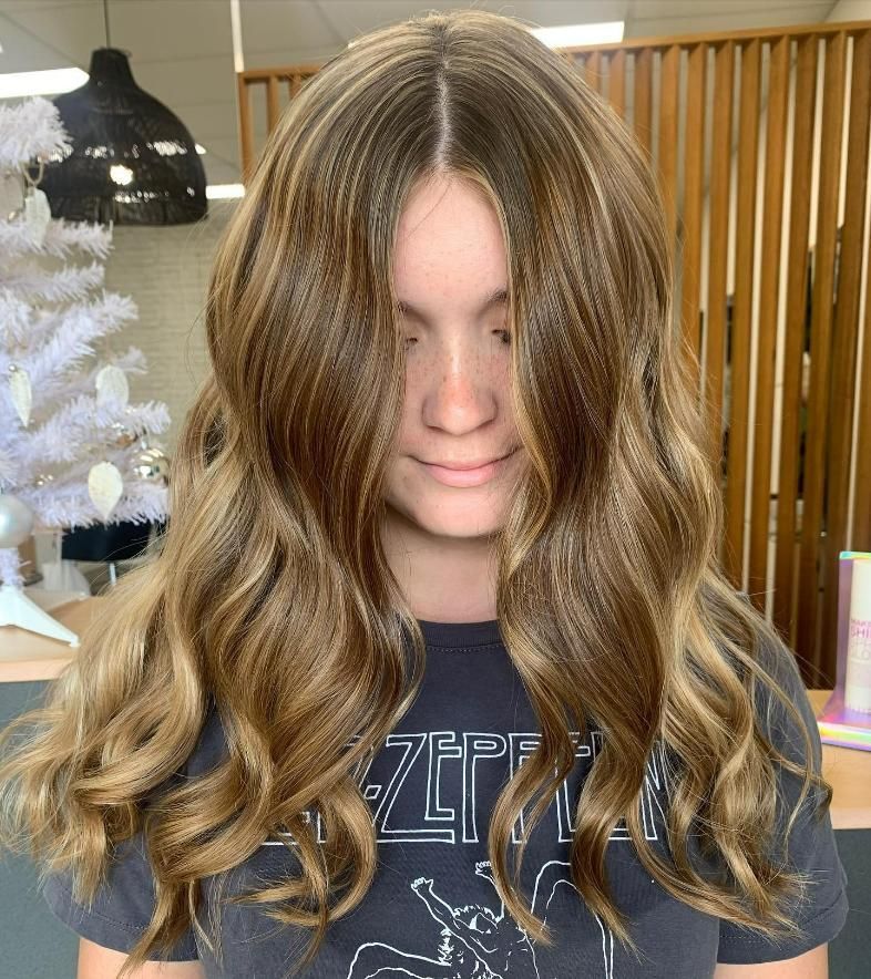A Woman with Long Brown Hair Is Wearing a Zeppelin Shirt — Eden Hair in Pacific Paradise, QLD
