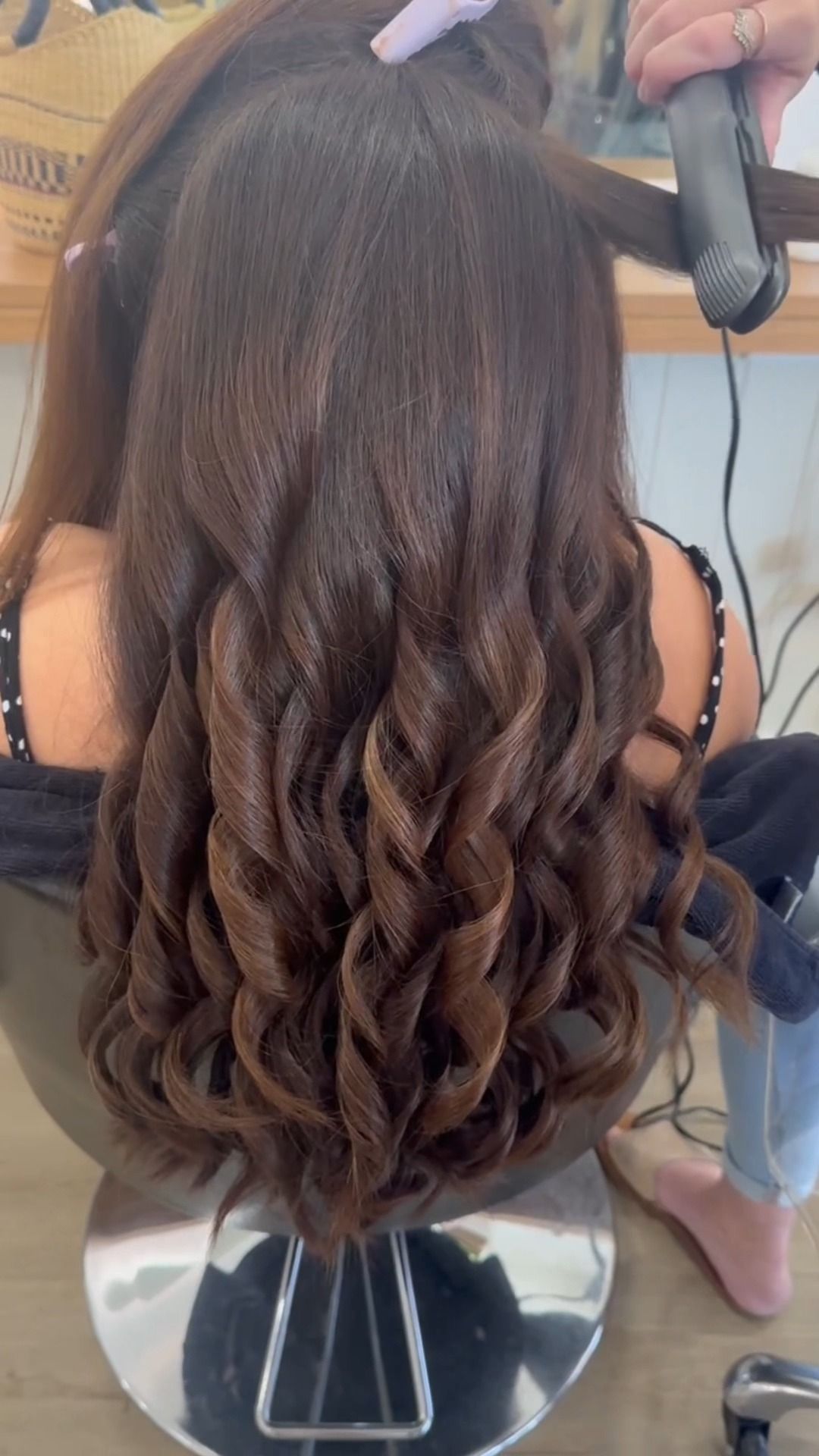 Person with long brown hair getting styled with curling iron in a salon — Eden Hair in Pacific Paradise, QLD