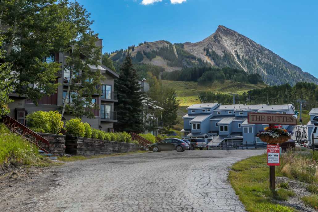 a dirt road leading to a building with a mountain in the background .