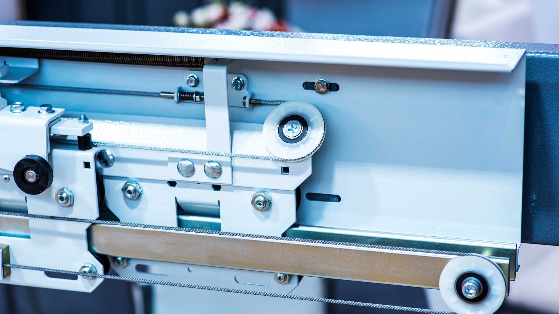 Close-up of a machine's internal mechanisms, showing a belt, rollers, and metal components.