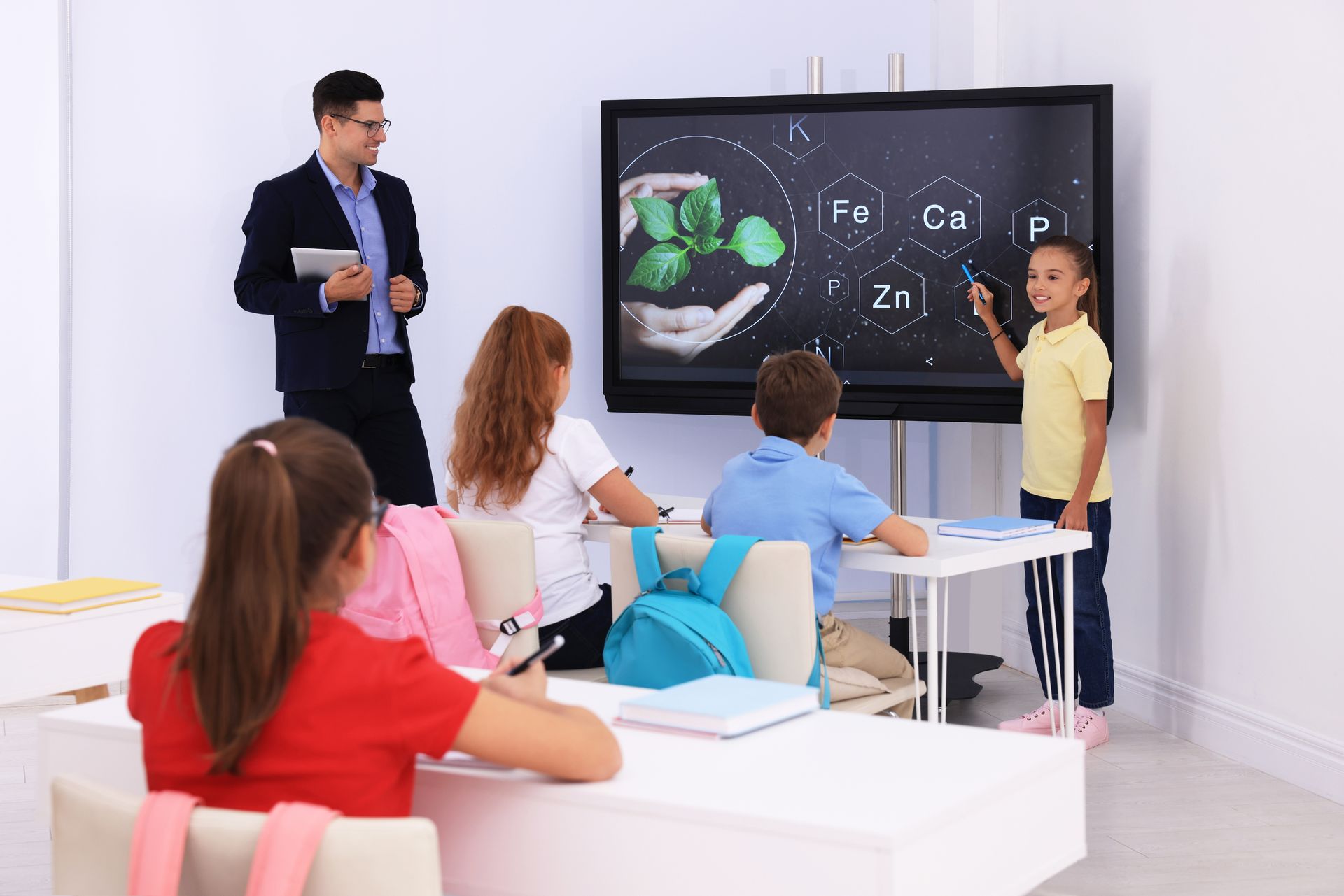 Classroom scene where students watch a presentation on nutrients shown on an interactive screen.