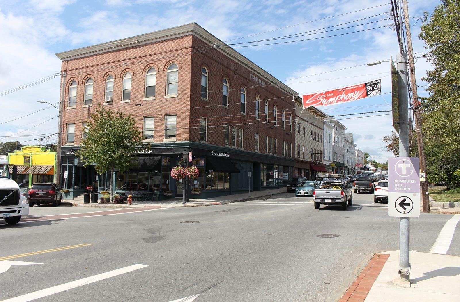 A busy intersection with a large brick building in the background