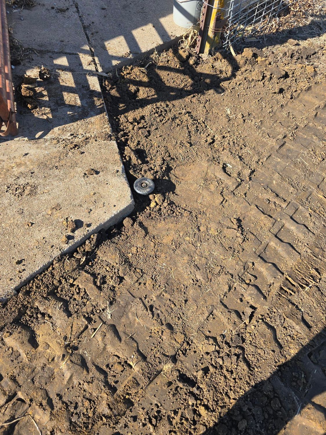 Dirt path with a concrete slab; a drainage pipe is visible.