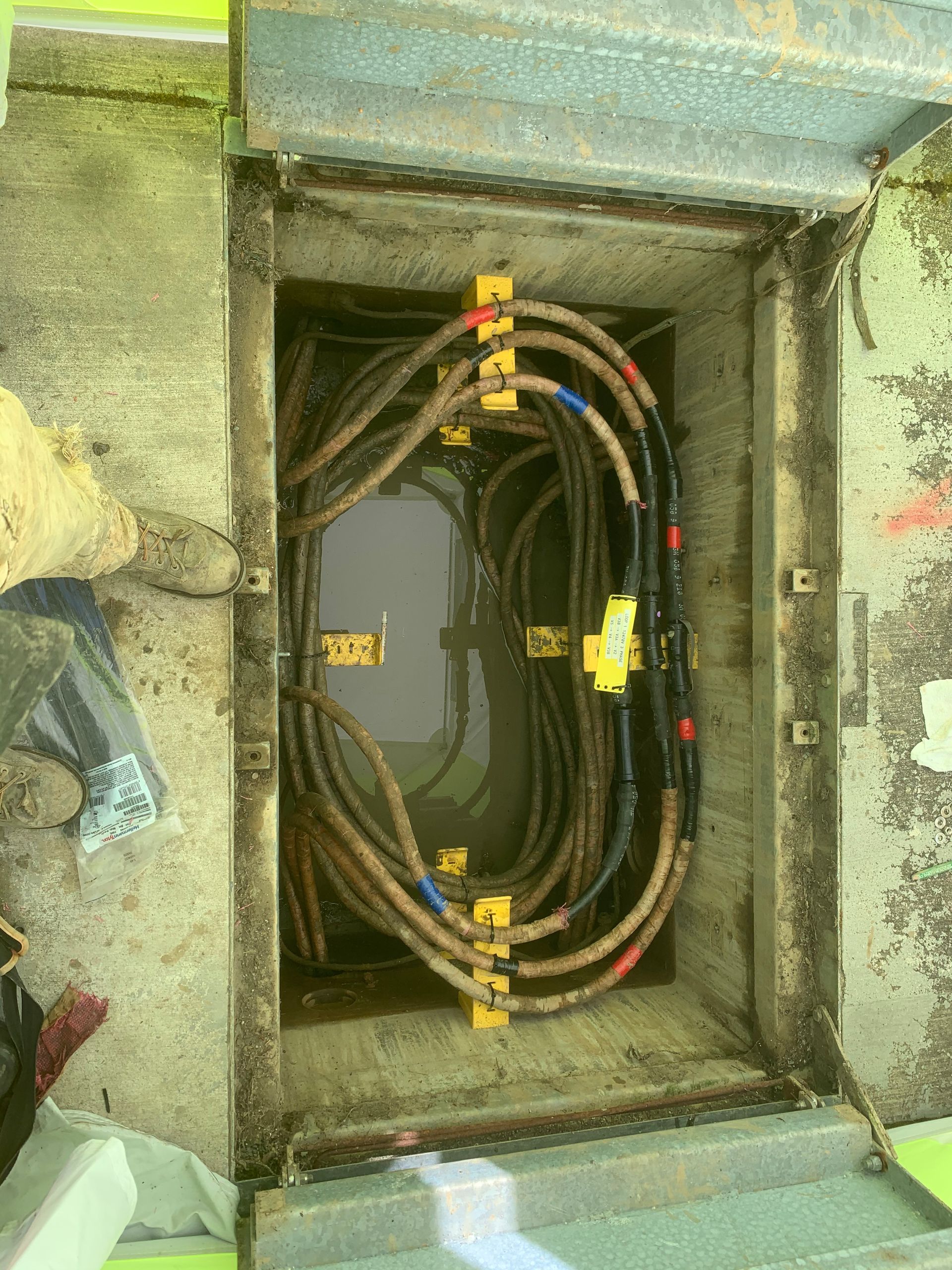 A bunch of wires are coming out of a hole in the ground.