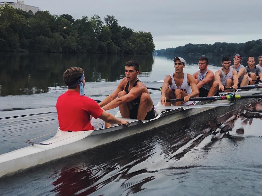A rowing team on a river practices.