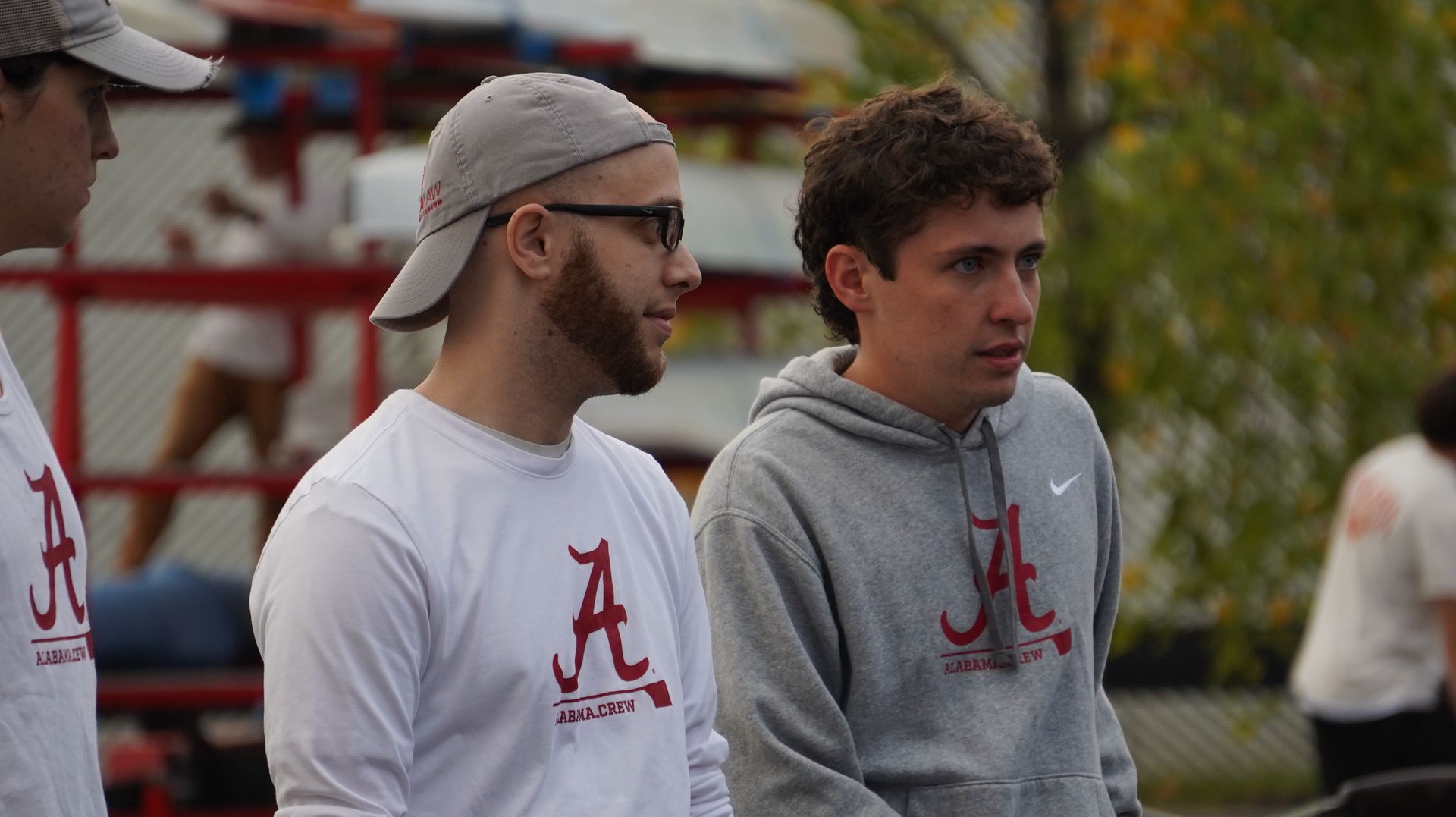 Three young men wearing white and gray shirts with the Alabama Crimson Tide 