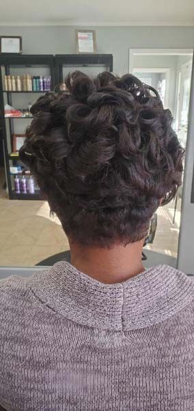 A woman is sitting in a chair with her hair in a bun.