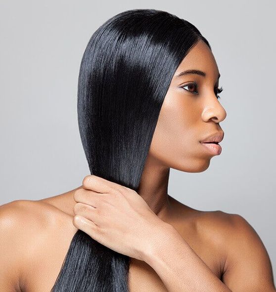 A woman with long black hair is touching her hair