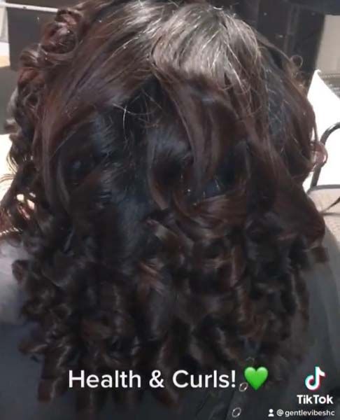 A close up of a woman 's hair with the caption health & curls