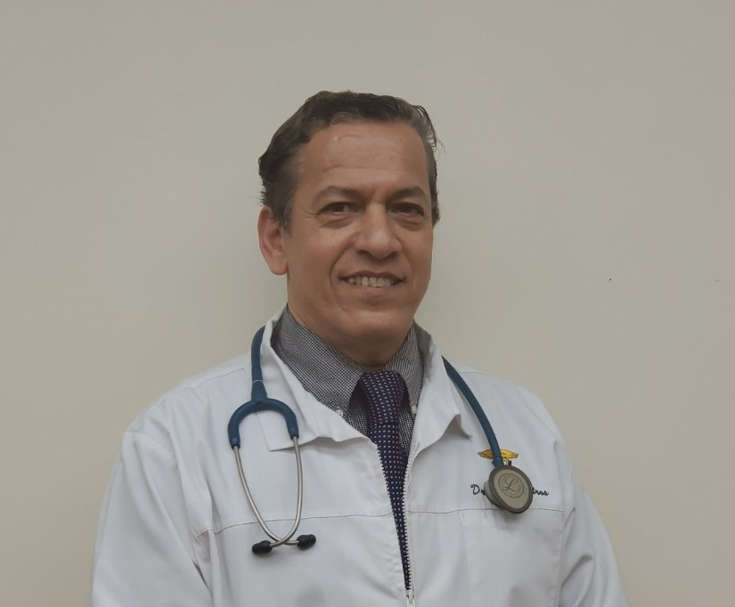 Dr. Botros in a white coat with a stethoscope around his neck