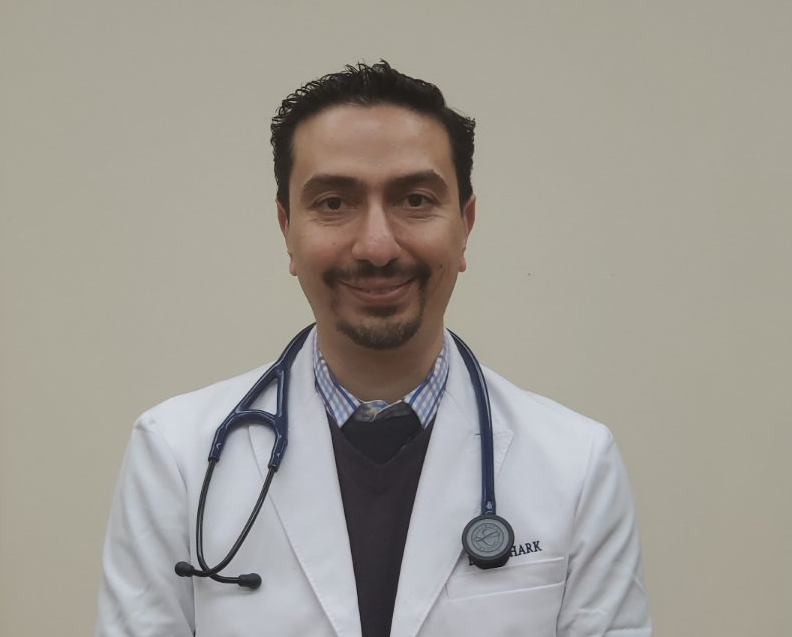 Dr. Shark in a white lab coat with a stethoscope around his neck