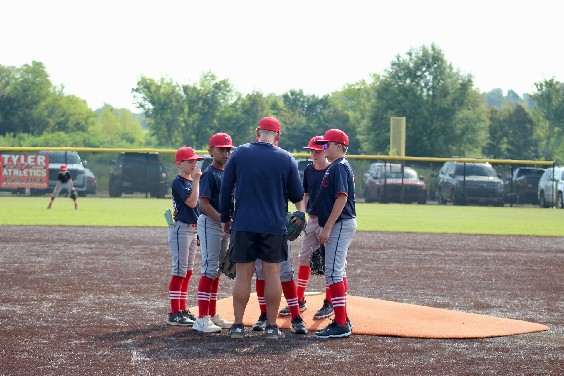 Young softball player in red helmet and jersey, batting.