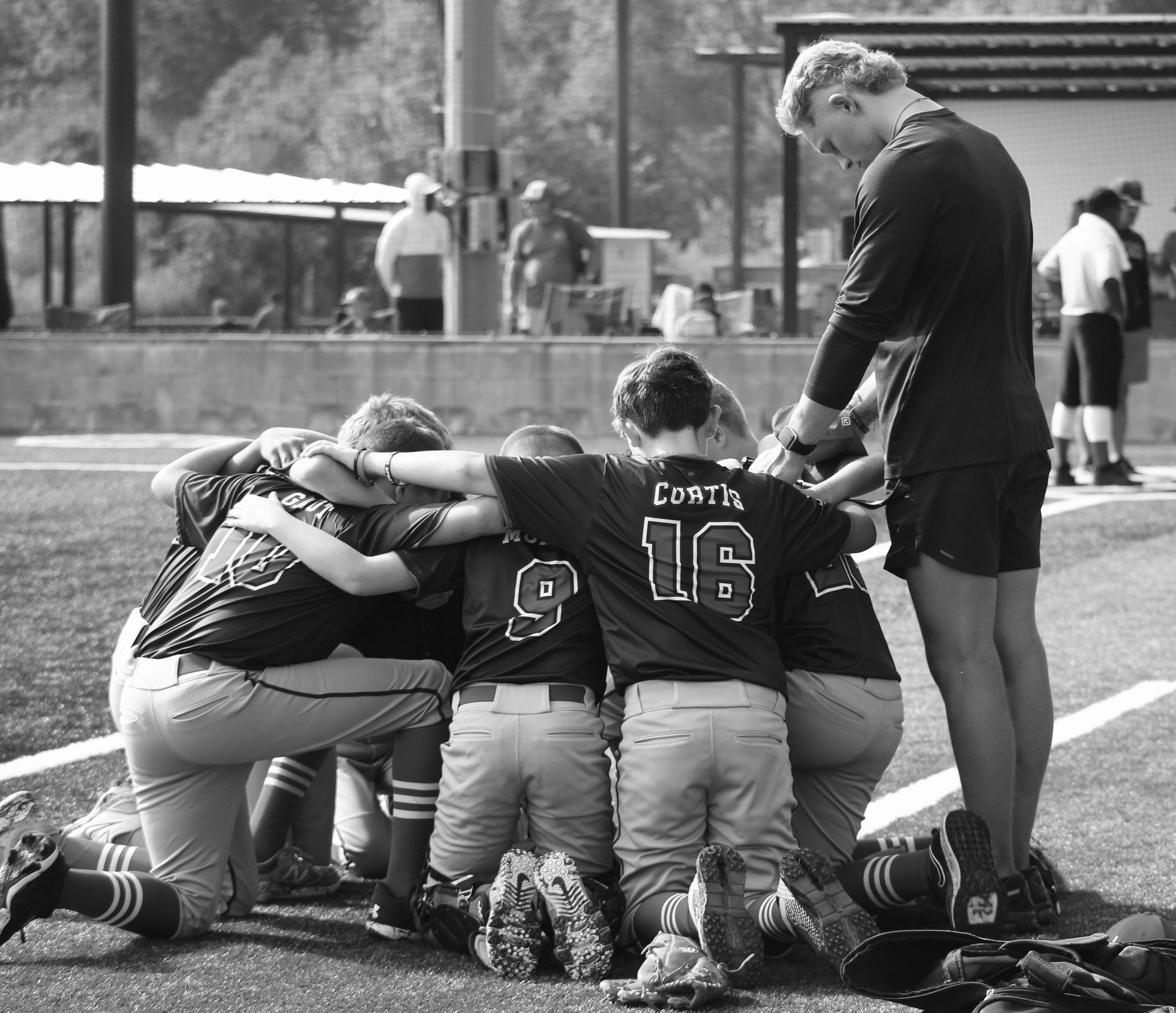 Boy in baseball uniform running on a field, wearing a helmet.