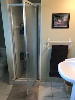 A bathroom with a shower, sink, and toilet