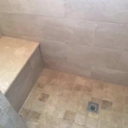 Tiled shower with beige tiles on walls and floor