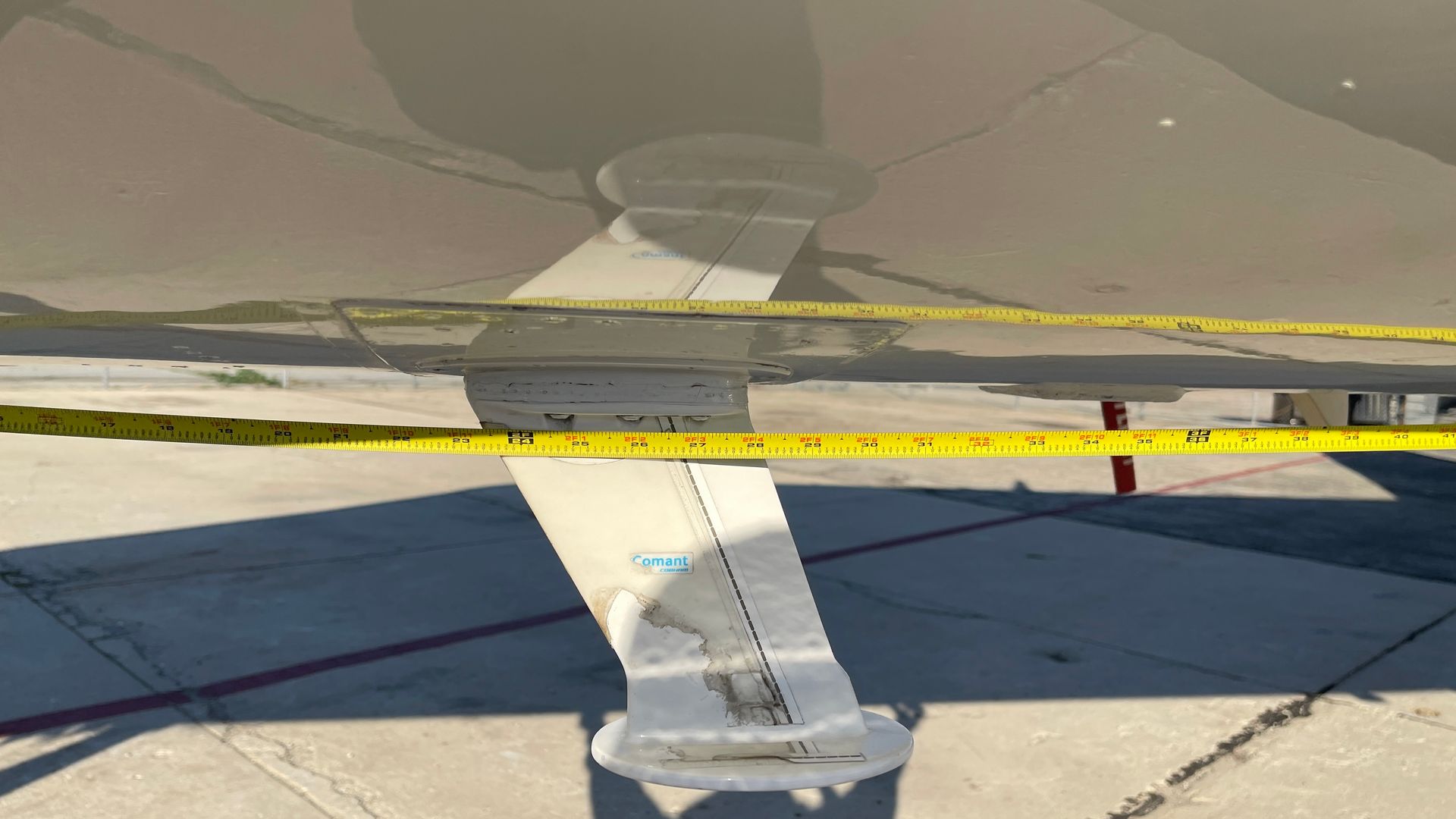 A close up of a plane wing with a yellow tape around it