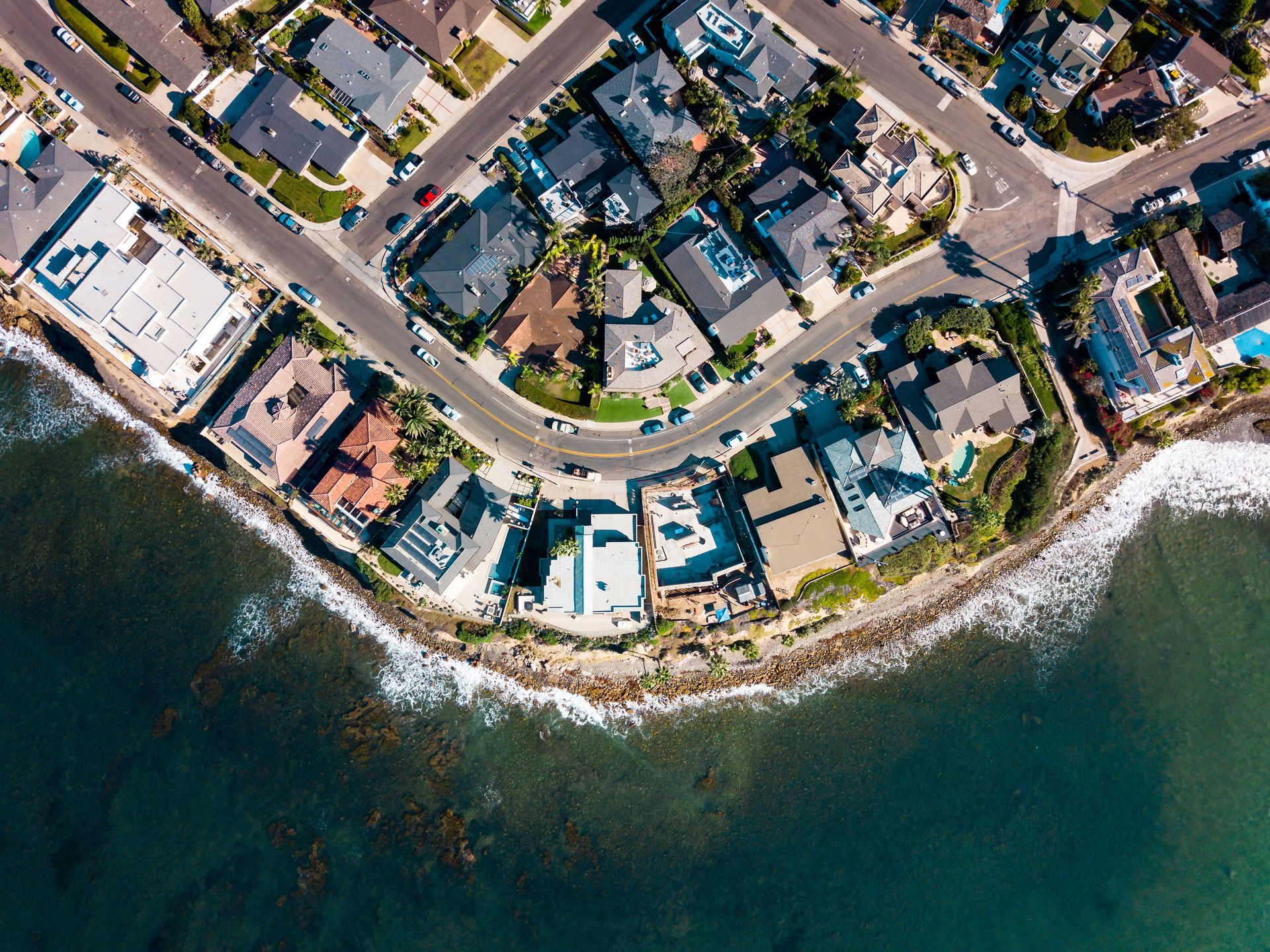 An aerial view of a residential area next to the ocean.