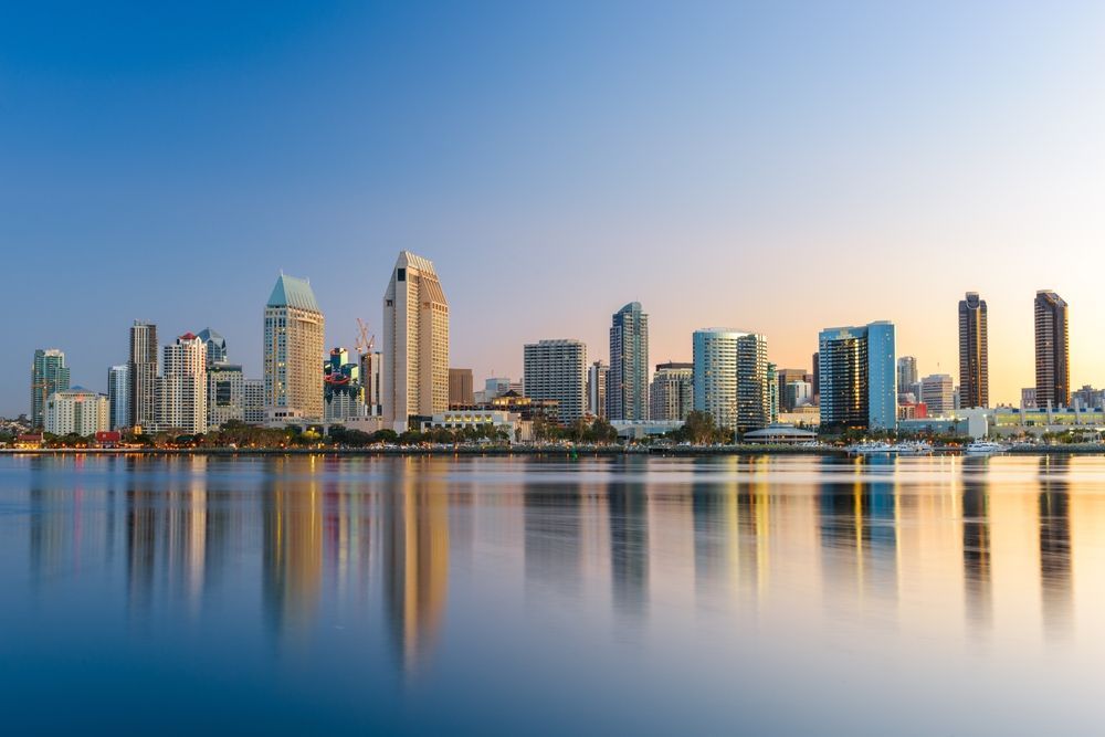 The skyline of san diego is reflected in the water.