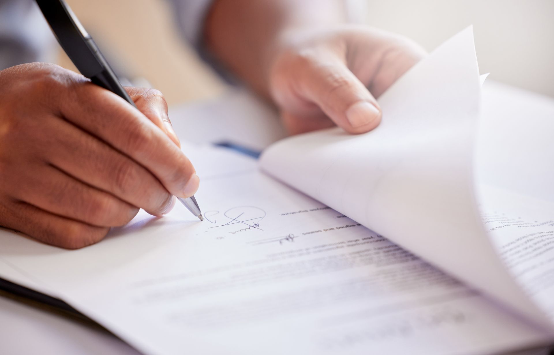 A person is writing on a piece of paper with a pen.