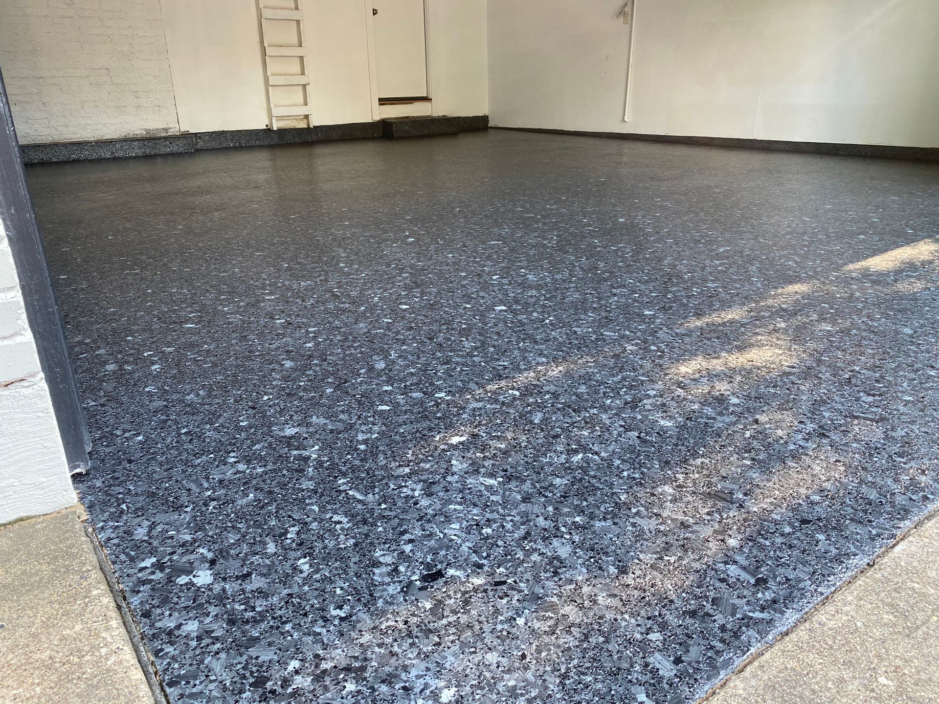 A garage floor with a ladder in the background.